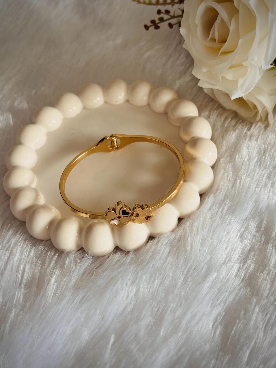 a slim polished gold bracelet with a black heart.