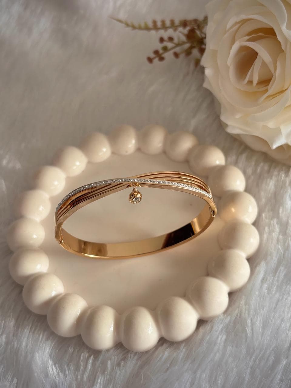 gold- toned bangle. modern curved layered design